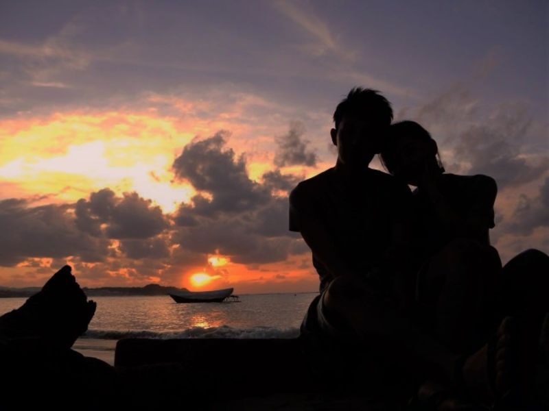 告白が成功して夕日を眺めているカップル